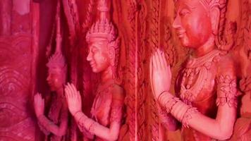 biddende muurfiguren sculpturen wat sila ngu rode tempel, thailand. video