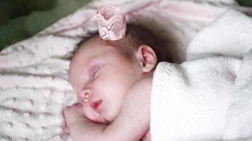 Nahaufnahme eines neugeborenen kleinen Babys, das auf dem Bett schläft, süße Träume des kleinen Babys, gesunder Schlaf