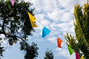 Flags for a garden party hanging between the trees photo