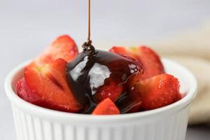 Strawberries in a bowl with chocolate sauce closeup photo