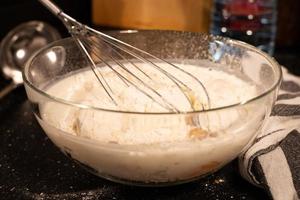 Preparation of the mass for pancakes. Mixed milk with flour in a bowl. photo