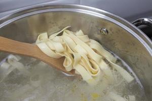 Pasta strips cooked in a kitchen pot. Close-up view. photo