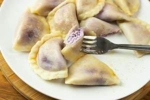 Dumplings stuffed with blueberries. Boiled in water, sprinkled with sugar and butter. photo