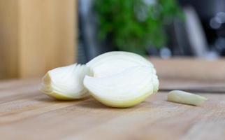 Pieces of onion lying on a wooden table. Preparation of ingredients for cooking. photo