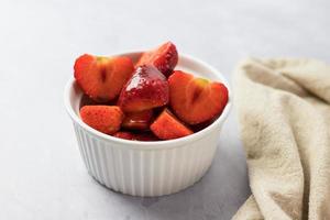 fresas en un recipiente sobre una mesa blanca foto