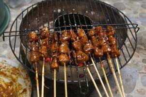 sate o satay es una de las comidas típicas de Indonesia. este alimento se elabora a base de pollo, ternera o cordero, el método de cocción es asado a la parrilla sobre brasas, aderezado con salsa de maní y salsa de soja. foto