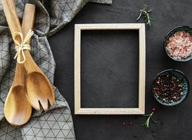 Old wooden kitchen utensils and spices with frame as a border photo