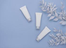 White tubes of cream on a blue background photo