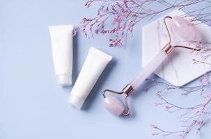 Cosmetic products, cream tubes and  face roller photo