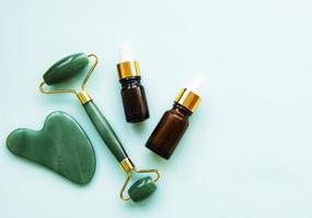 rodillo de jade de masaje facial con producto cosmético foto