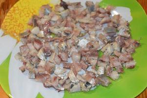 Slicing herring with a knife on a kitchen board photo