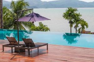 Beach chairs by the swimming pool with beautiful sea view photo