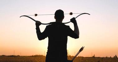 hombre con arco al aire libre en el campo foto