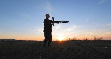 Silueta de joven luchador de kung fu practicando solo en los campos durante la puesta de sol foto