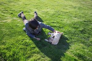 Retrato de mujer joven con perro pug en el parque foto