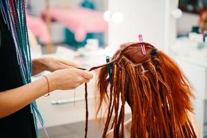 Braiding process african plaits with colored kanekalon. photo