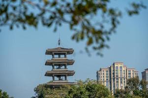 A tower under the blue sky and green trees photo