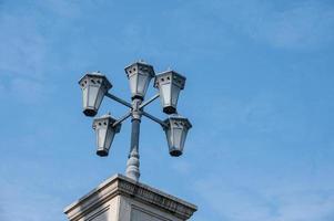 Five polygonal street lights under a pillar in the blue sky