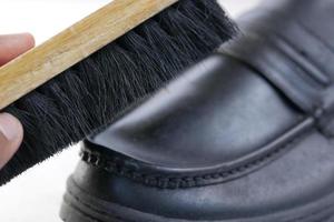 cleaning Shoe with a brush on floor photo