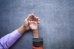 detail shot of young man holding hand of a senior women photo