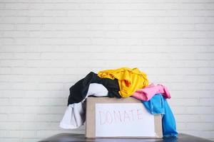 Donation box with donation clothes on table with copy space photo