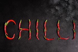 Bright red chilli pepper on a grey concrete background. Spicy food, ingredients photo