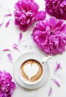 flores de peonía rosa y taza de café foto