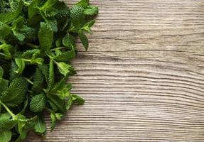 Fresh mint leaves on  old wooden background photo