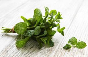 Fresh mint leaves on old wooden  background, flat lay photo
