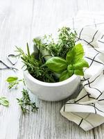 Bunch of aromatic herbs in mortar photo