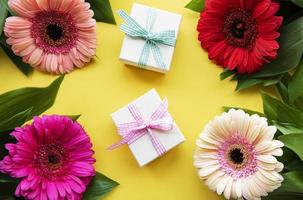Gerbera flowers and gift boxes on a yellow