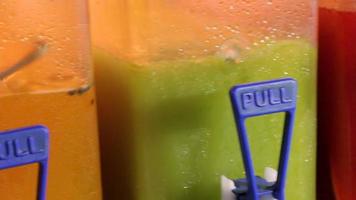 Three moist juice machines contatining cold fruit flavors shaved ice drinks video