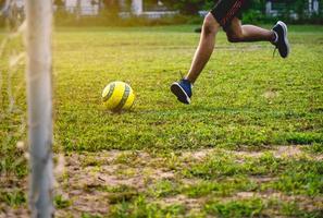 Entrenamiento de jugador de fútbol en campo de fútbol. joven futbolista practicando en el campo de fútbol.