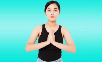 Retrato de linda mujer asiática exitosa, coreana muestra gesto de namaste sobre fondo azul, espacio de copia, concepto de joga fitness foto