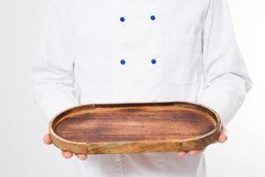 kitchener, cook holding empty wooden plate isolated on white background with copy space photo