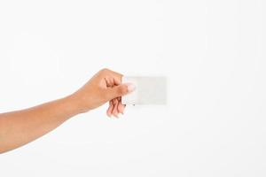 hand hold blank business card. female arm hold paper isolated on white background. copy space. mock up. photo