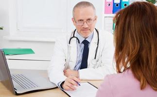 smiling doctor with patient in medical office photo