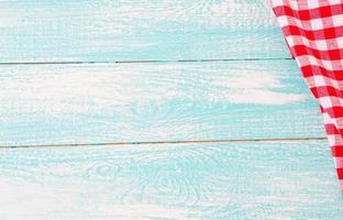 top view blue empty wooden table and red checkered tablecloth photo