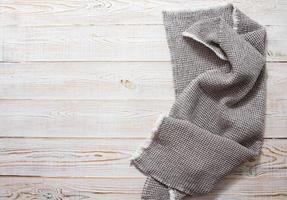 Gray linen napkin on white wooden table top view - close up photo