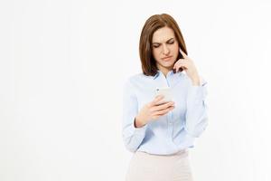 Upset woman holding a cellphone. Angry young businesswoman reading bad news on her cell phone. Isolated on white background.