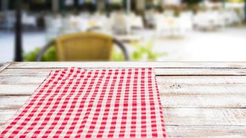 checkered red tablecloth on an empty table - top view photo