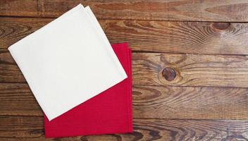 white and red napkin on empty wooden table - top view photo