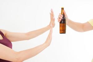 mano femenina rechazar una botella de cerveza aislado sobre fondo blanco concepto anti alcohol. copia espacio foto