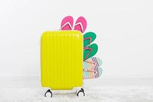 Yellow suitcase isolated on white background Summer holidays. summer flip flops or slippers.Sandals beach.Travel valise or bag. Mock up. Copy space. Template. Blank. photo