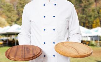 Close up chef holding wooden board boards in the kitchen street photo