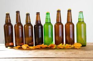 Beer bottles on a wooden table . Potato chips. Top view. Selective focus. Mock up. Copy space.Template. Blank.
