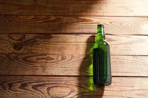 Beer bottle on a wooden table . Top view. Selective focus. Mock up. Copy space.Template. Blank. photo