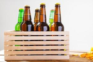 Beer bottles in wooden box. corrugated golden chips. Top view. Selective focus. Mock up. Copy space.Template. Blank. photo