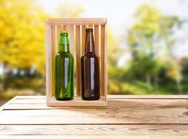 coloured beer bottles on wooden table on blurred park background