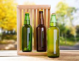 bottles beer on wooden table on blurred park background photo